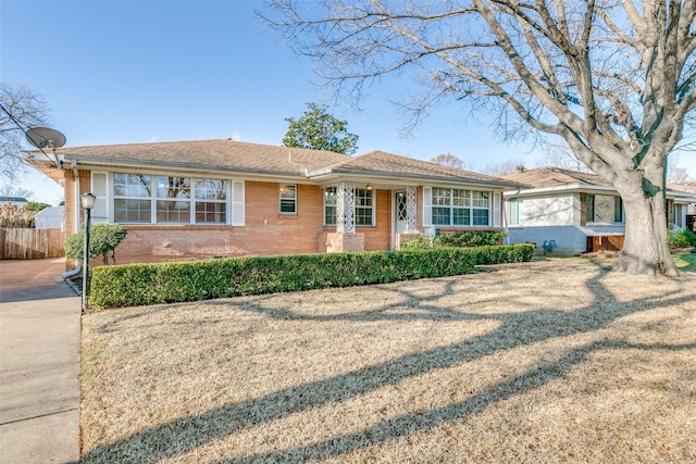 ranch-style home with a front yard and brick siding