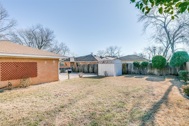 view of yard with a patio area, a storage unit, an outdoor structure, and a fenced backyard