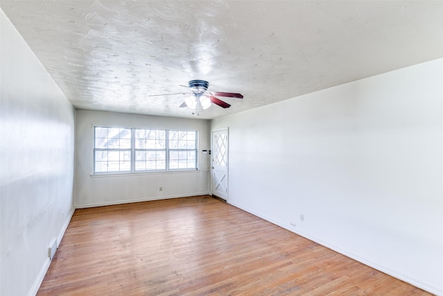 spare room with a ceiling fan, baseboards, and wood finished floors