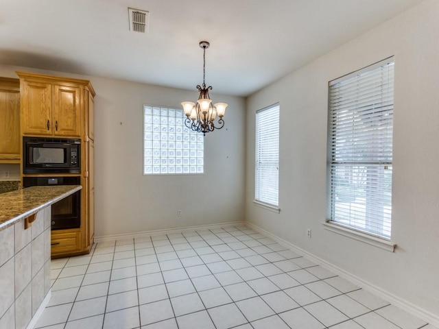 kitchen featuring a wealth of natural light, visible vents, a notable chandelier, and black appliances