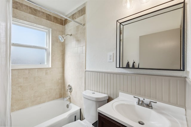 full bathroom with toilet, shower / bath combo, vanity, and wainscoting