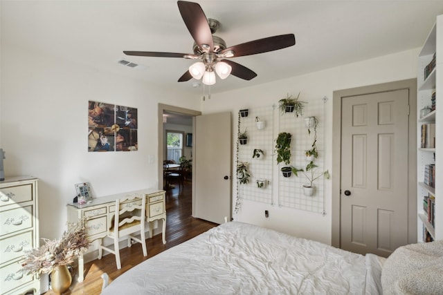 bedroom featuring a ceiling fan, visible vents, and wood finished floors