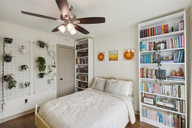 bedroom with dark wood-style floors, ceiling fan, and baseboards