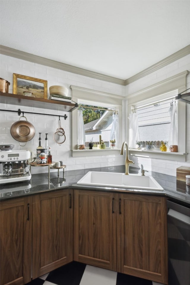 kitchen featuring dark countertops, dishwasher, tasteful backsplash, and a sink