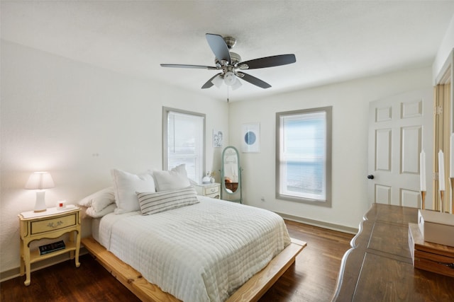 bedroom featuring dark wood-type flooring, a ceiling fan, and baseboards