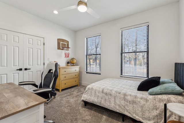 bedroom featuring carpet floors, a closet, baseboards, and a ceiling fan