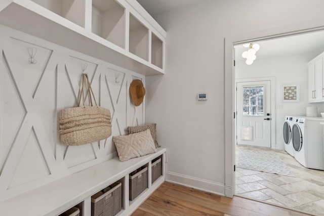 mudroom featuring washer and clothes dryer, light wood-type flooring, and baseboards