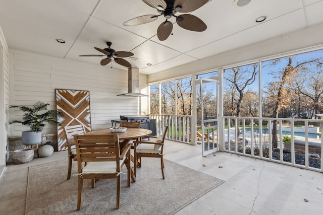 sunroom / solarium featuring a healthy amount of sunlight and ceiling fan