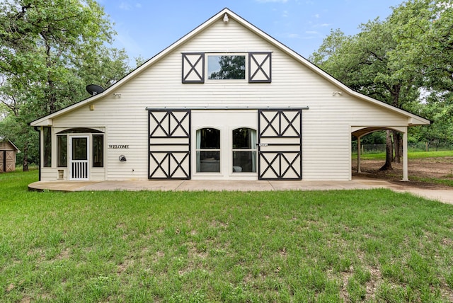 rear view of house with a barn, a lawn, and an outbuilding