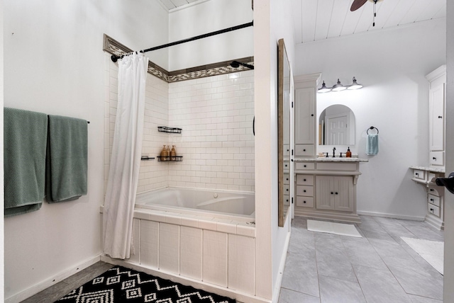 bathroom featuring tile patterned flooring, tiled shower / bath, baseboards, and vanity