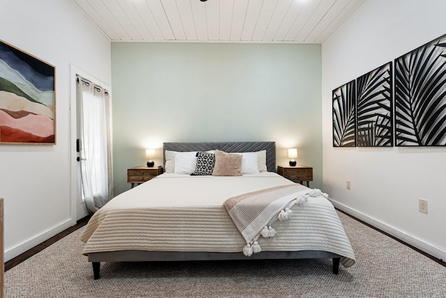 bedroom with wood ceiling, baseboards, and wood finished floors