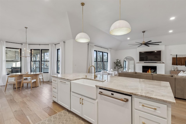 kitchen featuring a sink, light wood-type flooring, open floor plan, and dishwasher