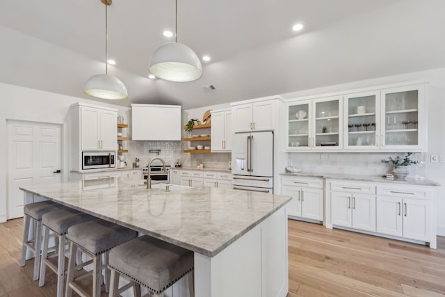 kitchen with high end white refrigerator, open shelves, backsplash, white cabinetry, and built in microwave