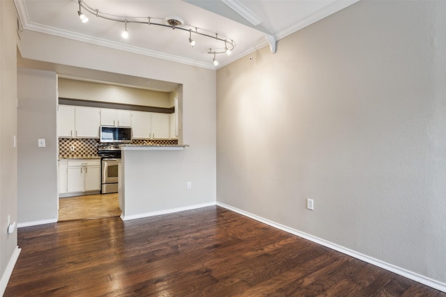 kitchen with white cabinets, wood finished floors, stainless steel appliances, crown molding, and backsplash