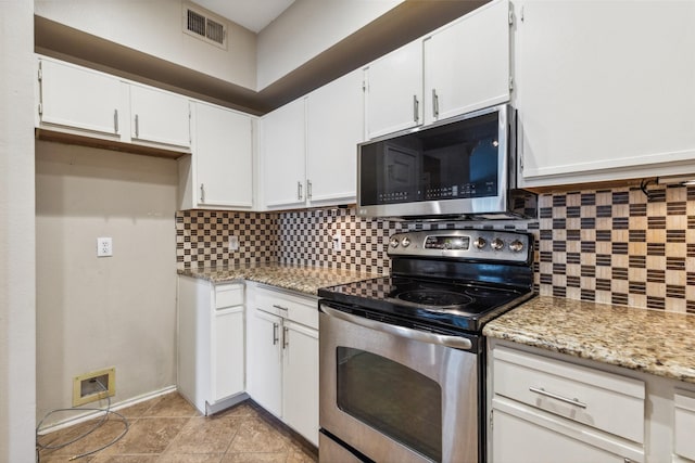 kitchen featuring appliances with stainless steel finishes, white cabinets, visible vents, and backsplash