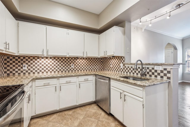 kitchen with appliances with stainless steel finishes, a sink, white cabinetry, and decorative backsplash