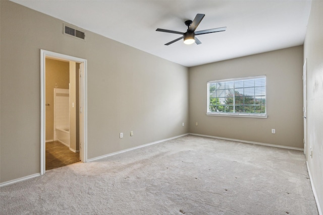 spare room with carpet floors, ceiling fan, visible vents, and baseboards