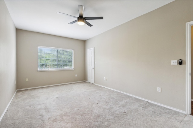 carpeted spare room with ceiling fan and baseboards