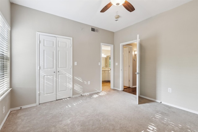 unfurnished bedroom with a closet, visible vents, carpet flooring, ceiling fan, and baseboards