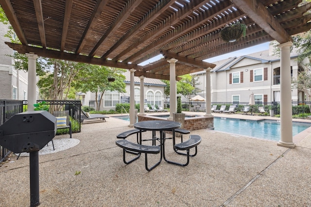 view of patio / terrace with a community pool, fence, and a pergola