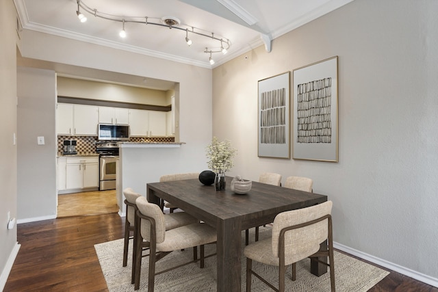 dining room featuring baseboards, dark wood finished floors, and crown molding