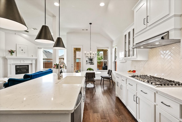 kitchen featuring a sink, a chandelier, tasteful backsplash, vaulted ceiling, and appliances with stainless steel finishes