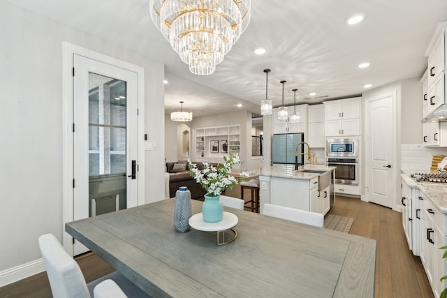 dining space featuring baseboards, dark wood-style flooring, a notable chandelier, and recessed lighting