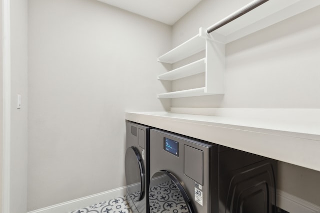 interior space with light tile patterned floors, laundry area, washer / clothes dryer, and baseboards