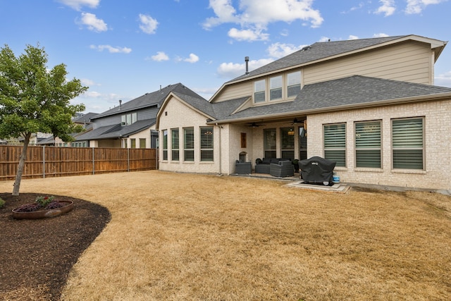 rear view of house with brick siding, a patio, a shingled roof, a ceiling fan, and fence