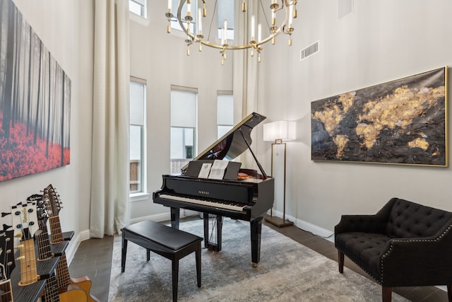 living area with a towering ceiling, wood finished floors, visible vents, and a healthy amount of sunlight