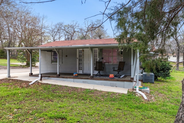 view of front of property featuring central air condition unit, covered porch, roof with shingles, crawl space, and a front yard