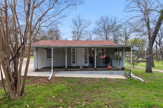 view of front of property featuring covered porch, a front lawn, and a shingled roof