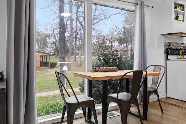 dining room featuring washer / dryer, a wealth of natural light, and wood finished floors