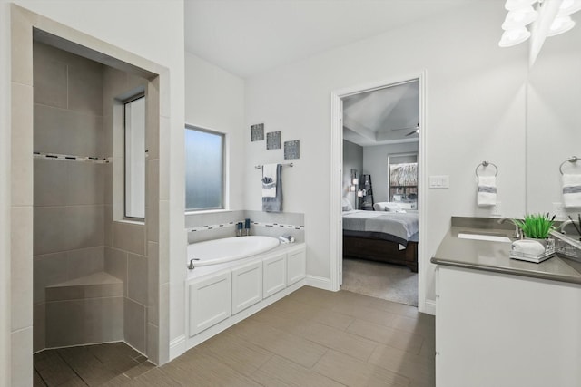 ensuite bathroom featuring a garden tub, ensuite bath, and vanity