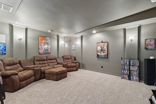 home theater room with a textured ceiling, carpet floors, visible vents, and ornate columns