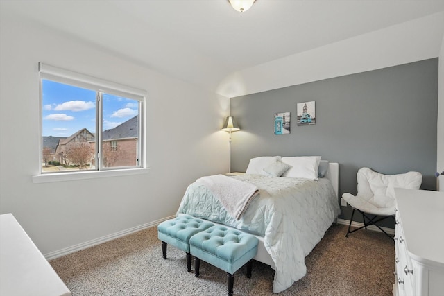 bedroom featuring dark colored carpet and baseboards