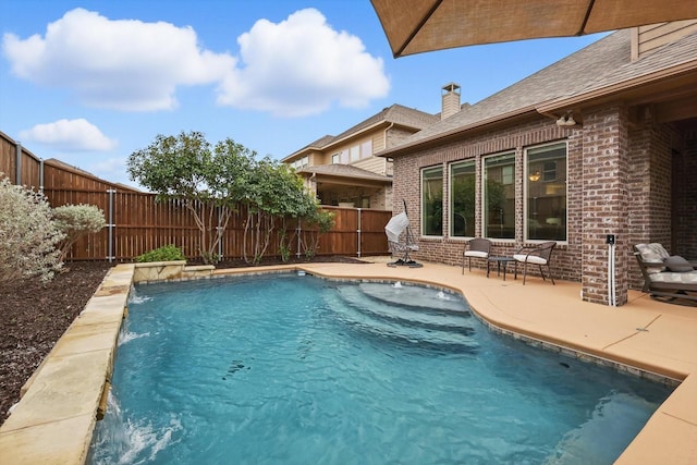 view of swimming pool featuring a patio area, a fenced backyard, and a fenced in pool