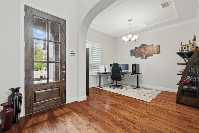 office area featuring arched walkways, ornamental molding, wood finished floors, and visible vents