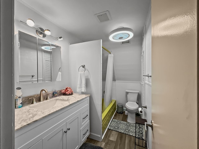 full bathroom with shower / bath combo, visible vents, toilet, wood finished floors, and vanity