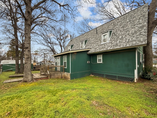 back of house featuring a shingled roof, a chimney, a deck, and a yard