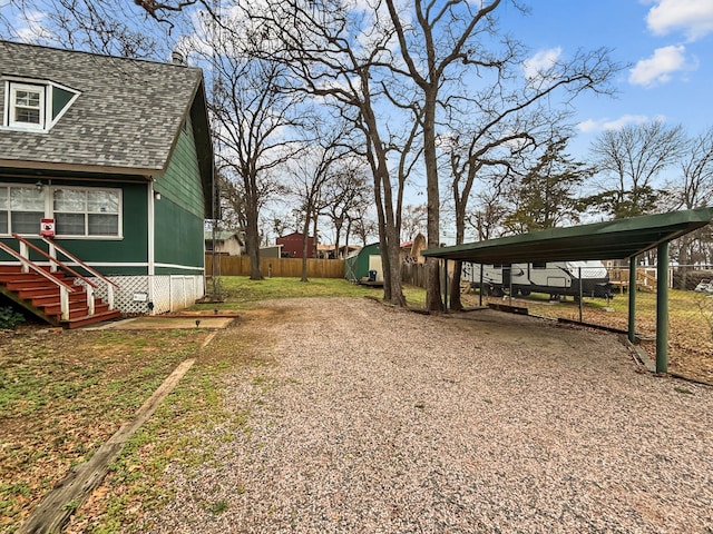 view of yard featuring gravel driveway and fence