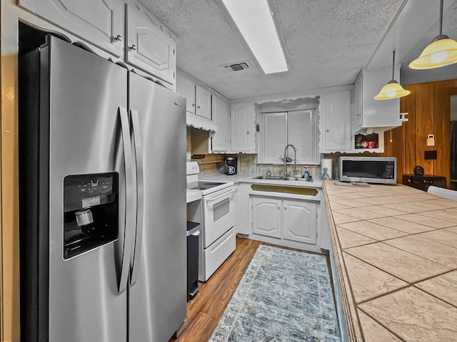 kitchen with visible vents, appliances with stainless steel finishes, light wood-style floors, white cabinets, and a sink