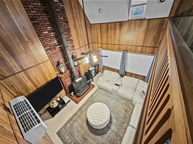 living room featuring wooden walls and a ceiling fan