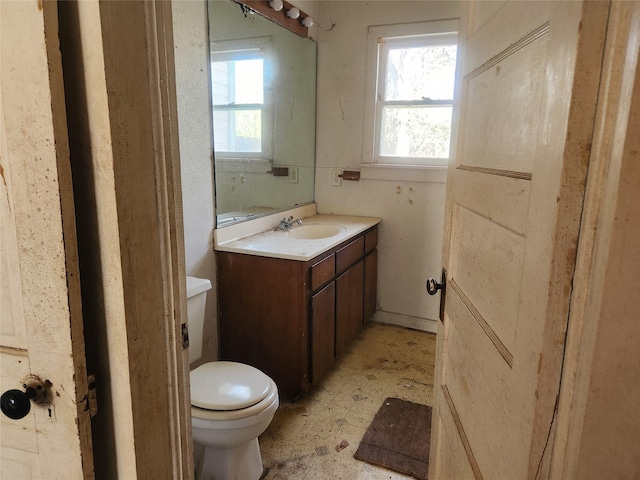 half bath with vanity, toilet, and tile patterned floors