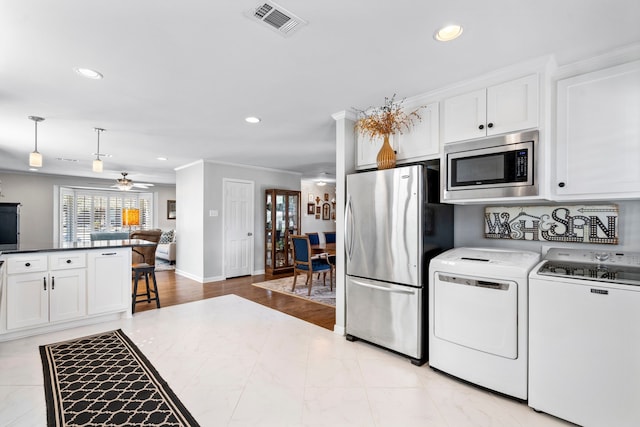 kitchen featuring visible vents, appliances with stainless steel finishes, washing machine and clothes dryer, white cabinetry, and recessed lighting