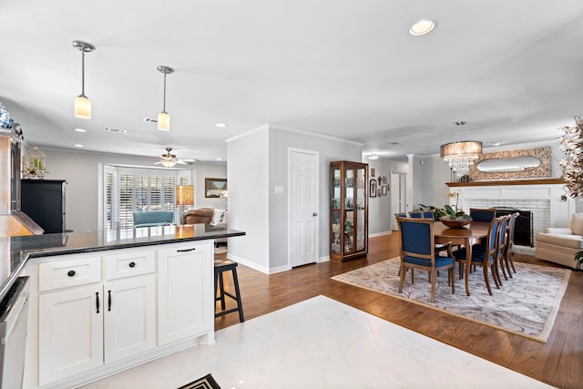 dining space with ornamental molding, recessed lighting, baseboards, and wood finished floors