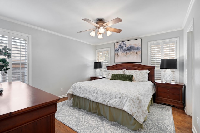 bedroom with ornamental molding, ceiling fan, baseboards, and wood finished floors