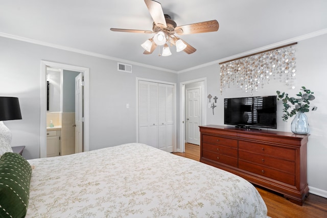 bedroom featuring visible vents, ensuite bathroom, wood finished floors, and ornamental molding