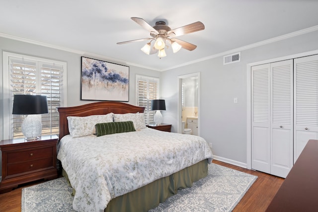 bedroom with visible vents, ornamental molding, wood finished floors, multiple windows, and a closet