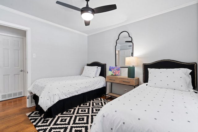 bedroom featuring crown molding, visible vents, ceiling fan, and wood finished floors